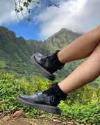 Close-up of black padded lace socks worn with black shoes