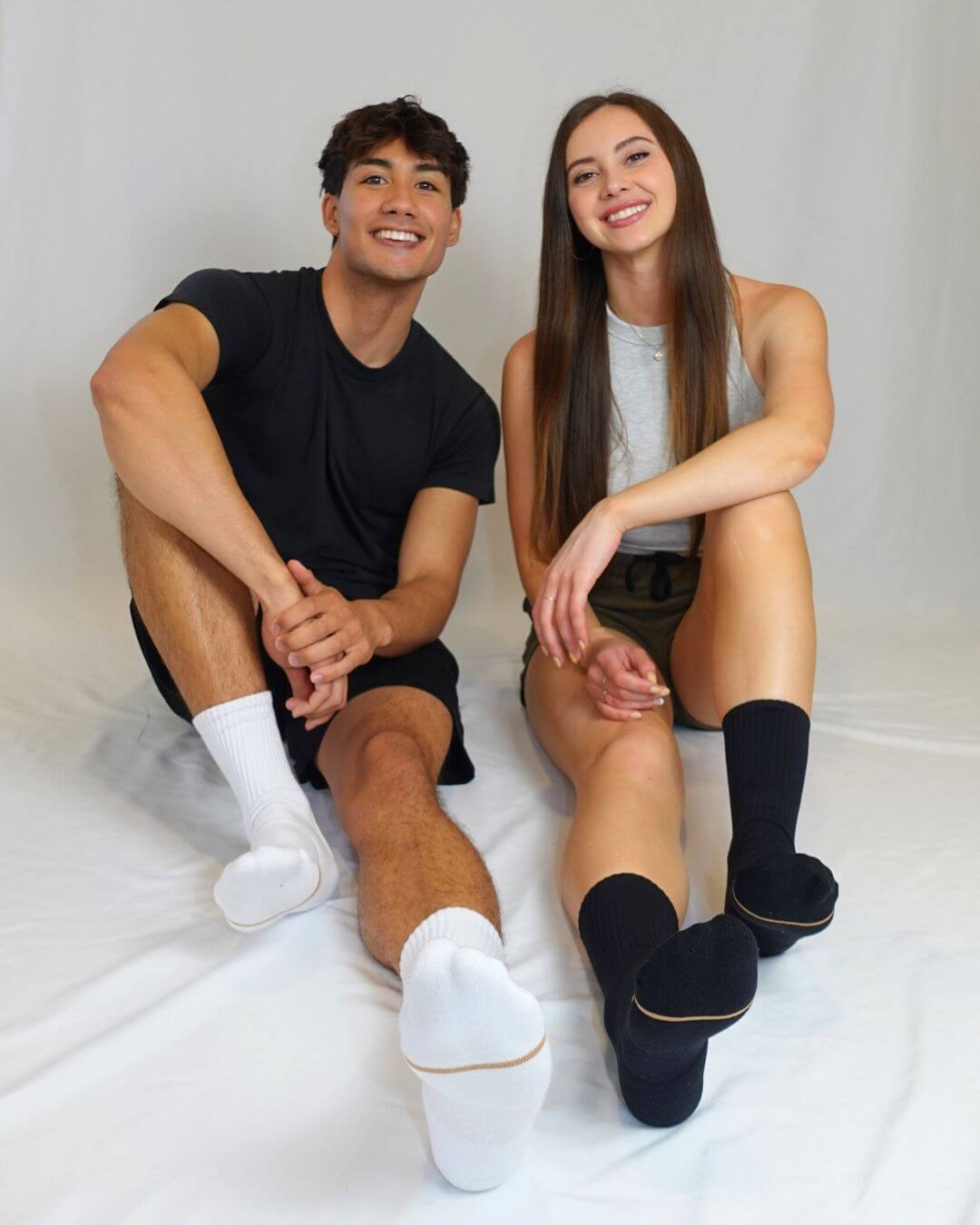 Two people seated wearing black Shezza unpadded socks