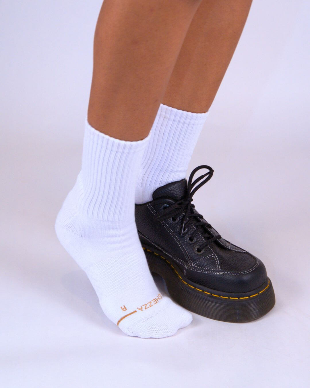 White padded crew socks worn with black Dr. Martens boots