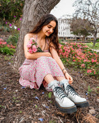 Woman sitting on grass wearing white padded lace socks with trainers