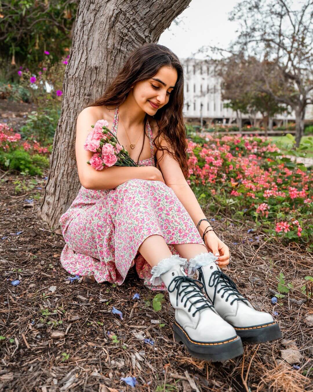 Woman sitting on grass wearing white padded lace socks with trainers